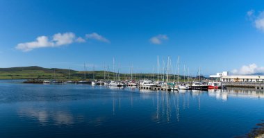 Dingle, Ireland - 7 August, 2022: view of many sailboats in the marina and harbor in Dingle village in County Kerry