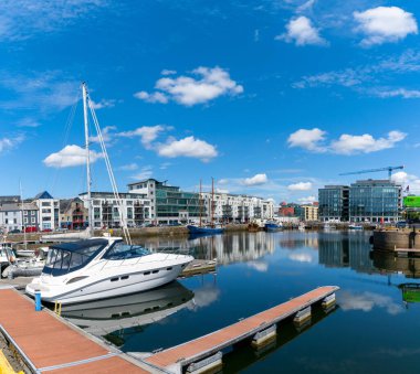 Galway, Ireland - 28 July, 2022: view of the industrial port and sports marina in Galway with reflections in the calm water