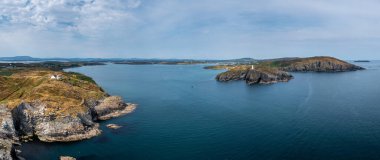 A panorama view of the entrance to the Baltimore Harbor in West Cork with teh Sherkin Island Lighthouse and the Baltimore Beacon
