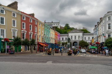 Cobh, İrlanda - 15 Ağustos 2022: Cobh şehir meydanı renkli evler ve Lusitania Anıtı heykeli