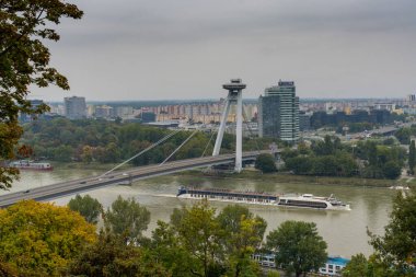 Bratislava, Slovakya - 25 Eylül 2022: Bratislava 'daki Tuna Nehri üzerindeki UFO Köprüsü' nün altından geçen bir nehir yolcu gemisi