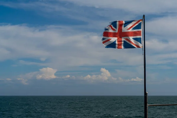 Zniszczona Podarta Flaga Union Jack Silnym Wietrze Błękitnym Oceanem Niebem — Zdjęcie stockowe