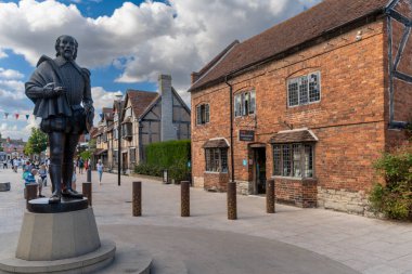 Stratford-Upon-Avon, Birleşik Krallık - 31 Ağustos 2022: William Shakespeare 'in heykeli ve Stratford şehir merkezi manzarası