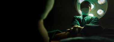 Doktorlar ameliyathanede acil kalp masajı yapıyor. Tıbbi yeterlilik gerektiren acil durumlar. Pankart boyutunda kopyalama alanı olan doktora odaklanmış seçim çekimi.