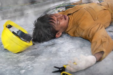 Şoktan sonra fabrika kontrol odasında yerde baygın yatan elektrikçi ya da bakım işçisinin iş kazası. Elektrik emme, iş konseptinde güvenli değil.