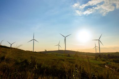 Günbatımında karamsar bir gökyüzü olan rüzgar türbinleri çiftliği yenilenebilir enerji sistemleri elektrik Asya 'da yel değirmenleri ile rüzgar enerjisi