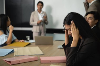 Konferans odasında toplanan masa yöneticisi ile ilgili birçok dosya stresli bir bayanın ve projektör monitörü ve dizüstü bilgisayarı olan niyet bayanın önünde hazır bulunmakta.