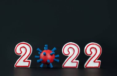 2022 rakamları ve siyah arka planda koronavirüs modeli. Noel konsepti, koronavirüs salgını sırasında yeni yıl. 