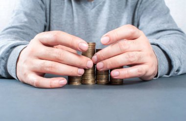 Para biriktirme kavramı. Bozuk paralar ve erkek elleri belirli bir arkaplanı kapatır