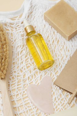 Pipet ve doğal cilt bakım ürünleri içeren cam içki bardağındaki dikey yakın çekim yağı.