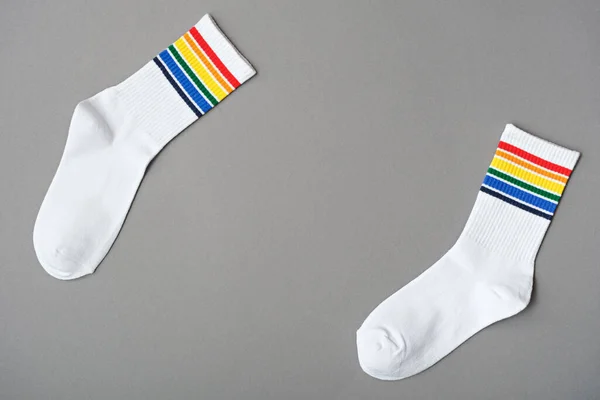 グレーの背景に虹色の白い綿の靴下 Lgbtqのシンボル Lgbtの友人への贈り物のアイデア モックアップ — ストック写真