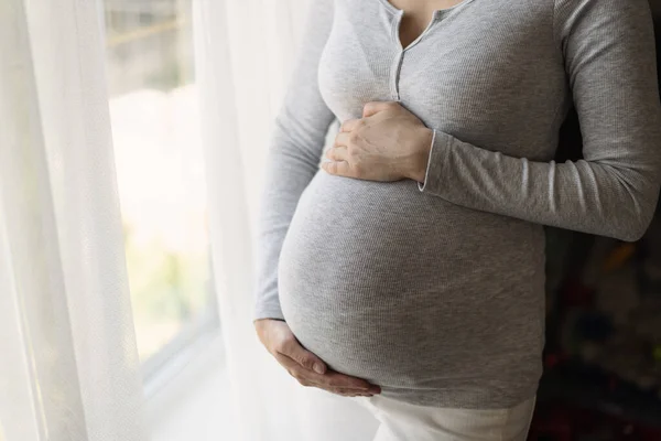 Primer Plano Mujer Embarazada Sudadera Gris Con Brazos Abrazando Vientre — Foto de Stock