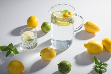 Limonata malzemeleri masanın üzerinde: limon, limon, nane, şeker. Bir bardak ve ferahlatıcı bir yaz içeceği sürahisi. Evde içki hazırlıyorum..