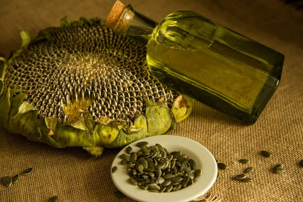 Ayçiçeği, ayçiçeği tohumu, ayçiçeği yağı, yağ üretimi, cam ayçiçeği yağı masanın üstünde, köy, ahşap zemin, bol masa örtüsü