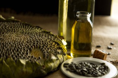 Ayçiçeği, ayçiçeği tohumu, ayçiçeği yağı, yağ üretimi, cam ayçiçeği yağı masanın üstünde, köy, ahşap zemin, bol masa örtüsü