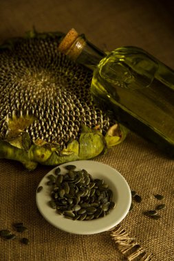 Ayçiçeği, ayçiçeği tohumu, ayçiçeği yağı, yağ üretimi, cam ayçiçeği yağı masanın üstünde, köy, ahşap zemin, bol masa örtüsü