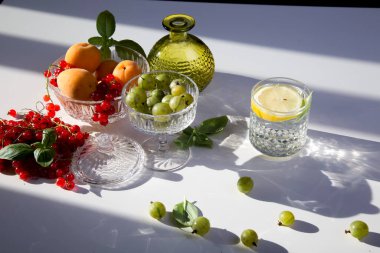 Böğürtlen, üzümler, üzümler, üzümler, limon, limon, portakal, kayısı. Mevsimlik yerel böğürtlen ve meyvelerin bir karışımı eski bir cam tabak ve bir altın antika tepside bulunur.