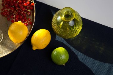 Böğürtlen, üzümler, üzümler, üzümler, limon, limon, portakal, kayısı. Mevsimlik yerel böğürtlen ve meyvelerin bir karışımı eski bir cam tabak ve bir altın antika tepside bulunur.