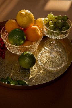 Böğürtlen, üzümler, üzümler, üzümler, limon, limon, portakal, kayısı. Mevsimlik yerel böğürtlen ve meyvelerin bir karışımı eski bir cam tabak ve bir altın antika tepside bulunur.