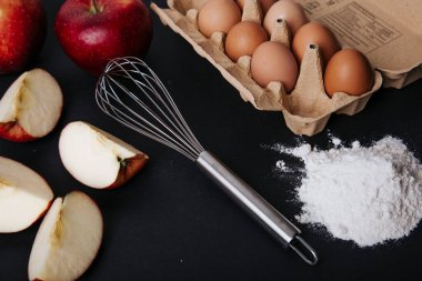 Elmalı turta malzemeleri mutfak masasında: yumurta, un, çırpı, elma, malzeme, ürün