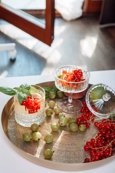 Summer refreshing drink from berries and fruits, house party, gooseberries and currants, lemonade in a glass