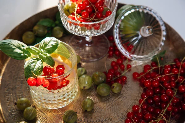 Summer refreshing drink from berries and fruits, house party, gooseberries and currants, lemonade in a glass