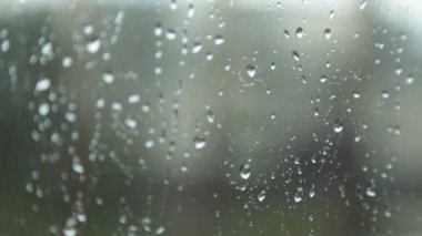 Pencereye yağmur damlaları, camdan aşağı akan yağmur damlaları, bulutlar, rahat bir ev.