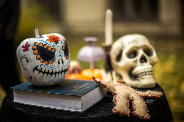 Scary human skull, Voodoo doll and pumpkin Halloween. Decor for All Saints Day. Scary background on Halloween. Toning.