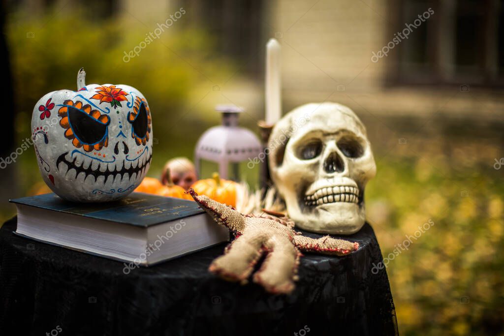 Cráneo humano aterrador, muñeca vudú y calabaza Halloween. Decoración