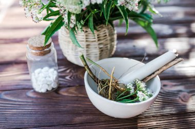 Valerian tablets with sedative properties. Pharmaceutical jar with pills on a wooden table. Cooking Valerian Root in a Mortar for Herbalism Elixirs. Soft focus
