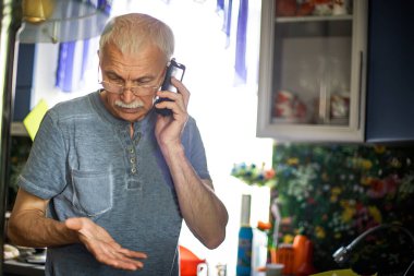 Evde 60 yaşında bir adam var. Kapalı mekanda akıllı telefonu olan ciddi bir ihtiyar. İçeride cep telefonu kullanan kıdemli bir iş adamının portresi. İnce gri saçlı, cep telefonu hareketleriyle yaşlı bir adam.