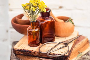 Sarı çiçekler yakın plan ölümsüzdür. Curry Plant, Herb of St. John, Immortelle ve botanik, Helchrysum arenyumu boş cam eczane şişelerinin yanında gerekli yağ için. Bitkibilimcilerin güzellik salonları için iksir yapmak.