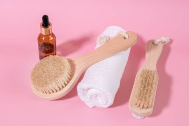Black glass unbranded cosmetic oil bottles. Natural organic spa cosmetics, eco friendly bathroom accessories. Wooden brush for cleansing the face and legs with natural bristles.