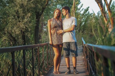 Doğada yaşayan güzel bir çift sazlıklarla kaplanmış bir nehrin üzerindeki tahta bir köprüde birbirlerine sarılıyorlar. Sevgililer Günü 'nü birlikte kutlayalım..