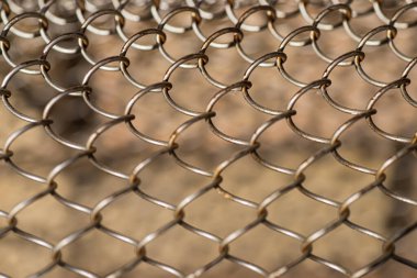 Mesh rabitz , texture of weaving mesh network link. Close up of a fence. barrier on way. metal grid close-up. rusty mesh texture.