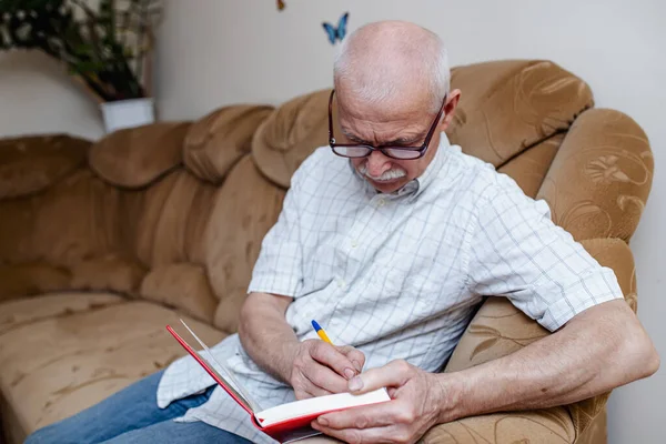 Oudere Man Neemt Notities Een Notitieboekje Het Betalen Van Rekeningen — Stockfoto