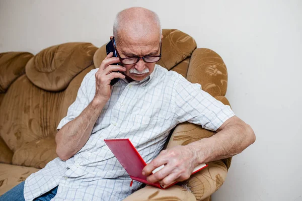 Elderly Man Speaks His Cell Phone Checking Data Paper Notebook — Stock Photo, Image