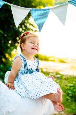 Küçük kız içten bir şekilde gülümsüyor ve gözlerini mahvediyor. Çocuk bacak bacak üstüne attı. Yürümeye yeni başlamış küçük ayakçı. Bir çocuk sahilde dinleniyor.