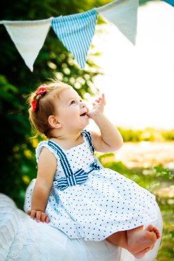 Küçük kız içten bir şekilde gülümsüyor ve gözlerini mahvediyor. Çocuk bacak bacak üstüne attı. Yürümeye yeni başlamış küçük ayakçı. Bir çocuk sahilde dinleniyor.