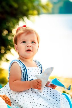 Oyuncak tekne tutan bir çocuk. Nehrin kıyısındaki kumda bir çocuk oturuyor. Doğada ailelerle tatiller.