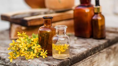 Hypericum perforatum, St. Johns wort apothecary bottles with tincture and essential oils for beauty salons and alternative medicine