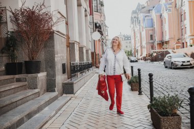 Mutlu orta yaşlı kadın turist gezisinde şehir turunu geziyor.