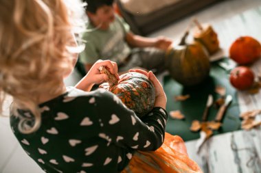 Bir kız Cadılar Bayramı 'nda oymak için uygulanan bir balkabağı tutuyor. Balkabağından bir balkabağı feneri yapmak.