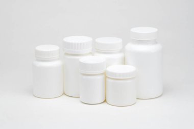 Beyaz arka planda beyaz plastik ilaç kavanozları. İzole edilmiş