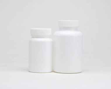 Beyaz arka planda beyaz plastik ilaç kavanozları. İzole edilmiş