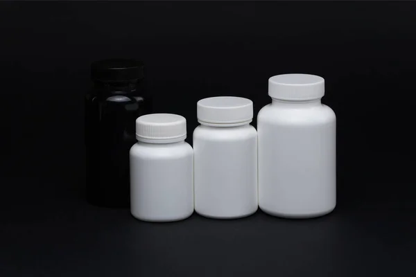白色和黑色塑料药丸罐黑色背景 被隔离了 — 图库照片