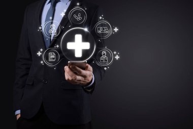 İş adamının elinde sanal ve tıbbi ağ bağlantısı simgeleri var. Covid-19 salgını insanları bilinçlendirir ve sağlık hizmetlerine dikkat çeker. Doktor, belge, ilaç, ambulans, hasta ikonu