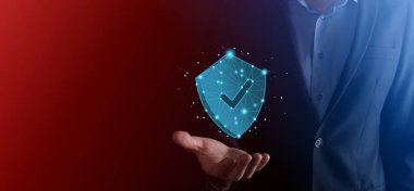 İşadamı poligon kalkanını kene ikonu ile düşük tutuyor.Güvenli Erişim Sistemi Konsepti. Yatırım için İş Mali Garanti. Antivirüs konsepti. Teknoloji güvenliği. Koruma ağı, güvenli veri.