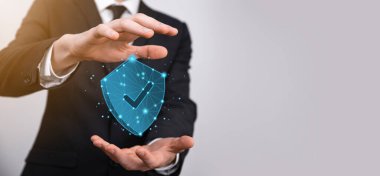 İşadamı poligon kalkanını kene ikonu ile düşük tutuyor.Güvenli Erişim Sistemi Konsepti. Yatırım için İş Mali Garanti. Antivirüs konsepti. Teknoloji güvenliği. Koruma ağı, güvenli veri.