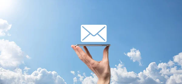 Businessman hand holding e-mail icon, Contact us by newsletter email and protect your personal information from spam mail. Customer service call center contact us concept.